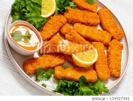 フライドフィッシュフィンガースティックまたはフライドポテトフィッシュソースセット、フライパン、黒い木製のテーブルの上Premium写真