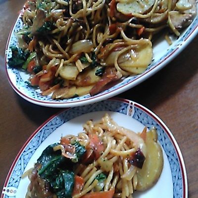 和田明日香さんの『カレーしょう油焼きそば』 ①玉ねぎ1 2個を薄切り、にんじん70gを短冊切り、ジャガイモ1個を半月切り、ソーセージ6本を斜めに切る②フライパンにサラダ油大さじ2をひき、玉ねぎとソーセージを入れ、その上に袋ごと半分に切った蒸し中華麺3袋分を