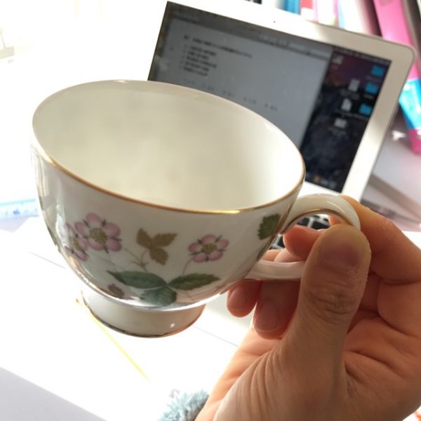 テーブルの上にコーヒーカップを持つ手の写真・画像素材-Snapmart スナップマート