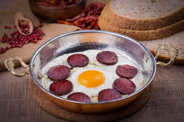 トルコ料理の銅鍋にソーセージと卵を入れて揚げたもの。トルコ風。Premium写真