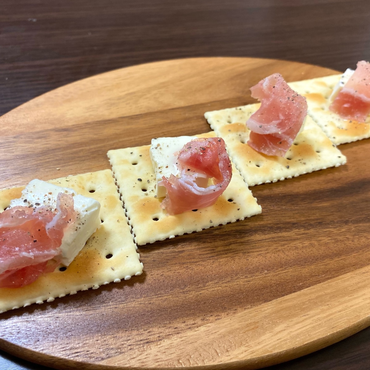 木製の背景にハム、生ハム、サラミ、チーズ、クラッカー、オリーブの前菜盛り合わせ。クリスマステーブル。の写真素材・画像素材 Image 135485934